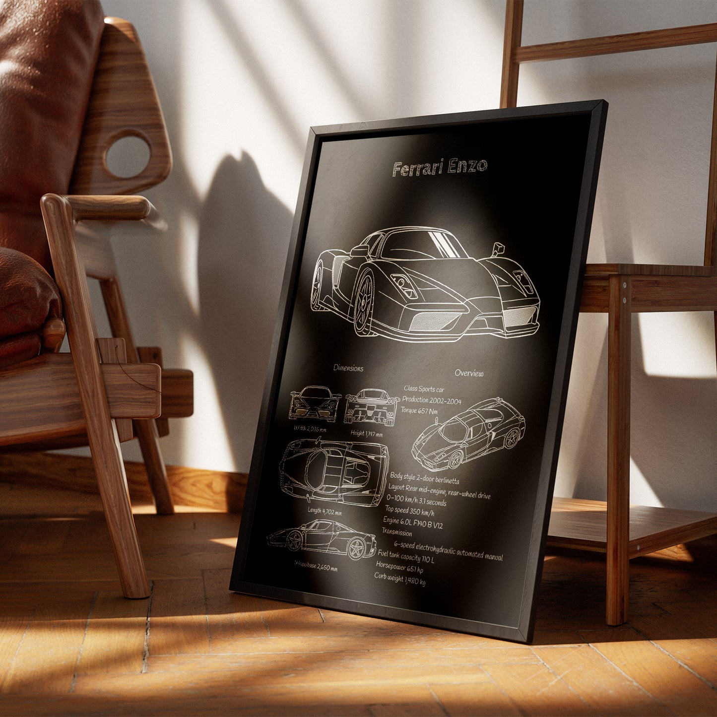 Framed poster of a Ferrari Enzo design on a wooden floor with a chair and table in the background.