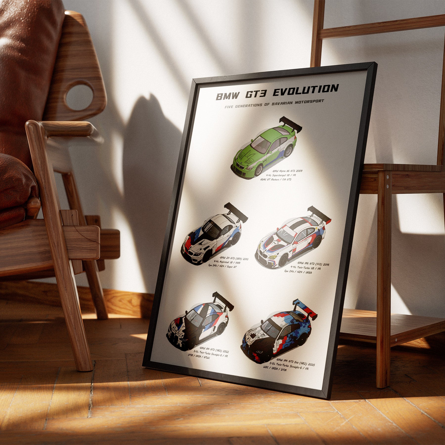 A framed BMW GT3 Evolution poster leaning against a wooden chair in a sunlit room with wood floors and a white wall.