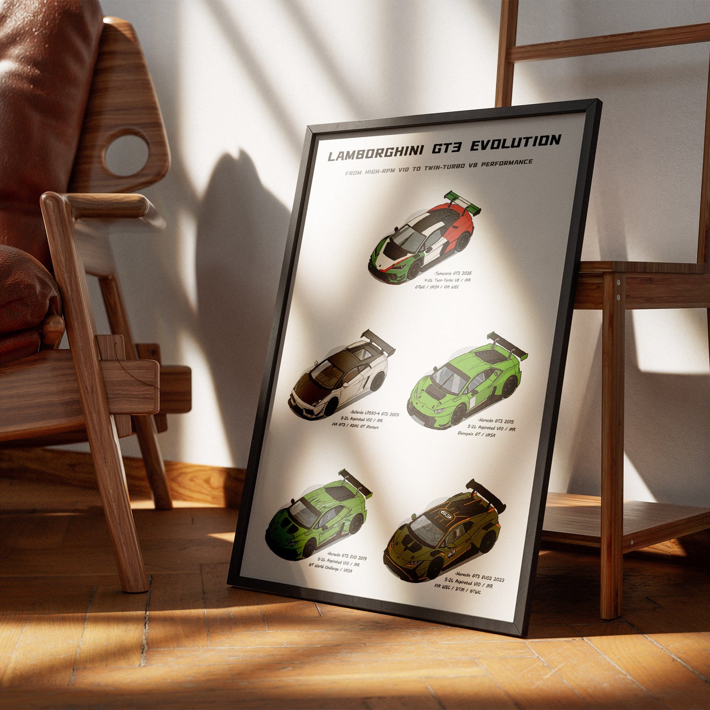 A framed poster titled 'Lamborghini GT3 Evolution' leaning against a wooden chair in a sunlit room. The poster shows four Lamborghini GT3 race cars in different color schemes on a light background.