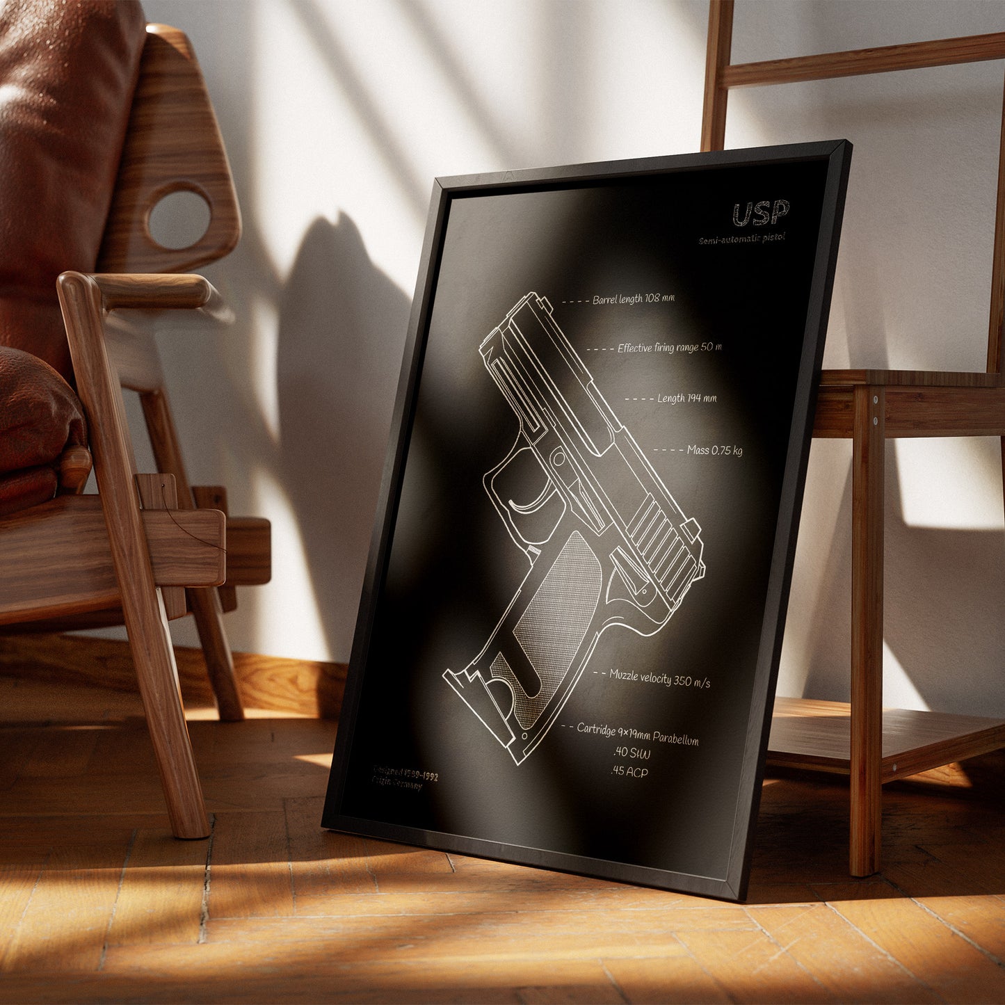 Framed blueprint of USP pistol on a wooden floor with chairs in the background